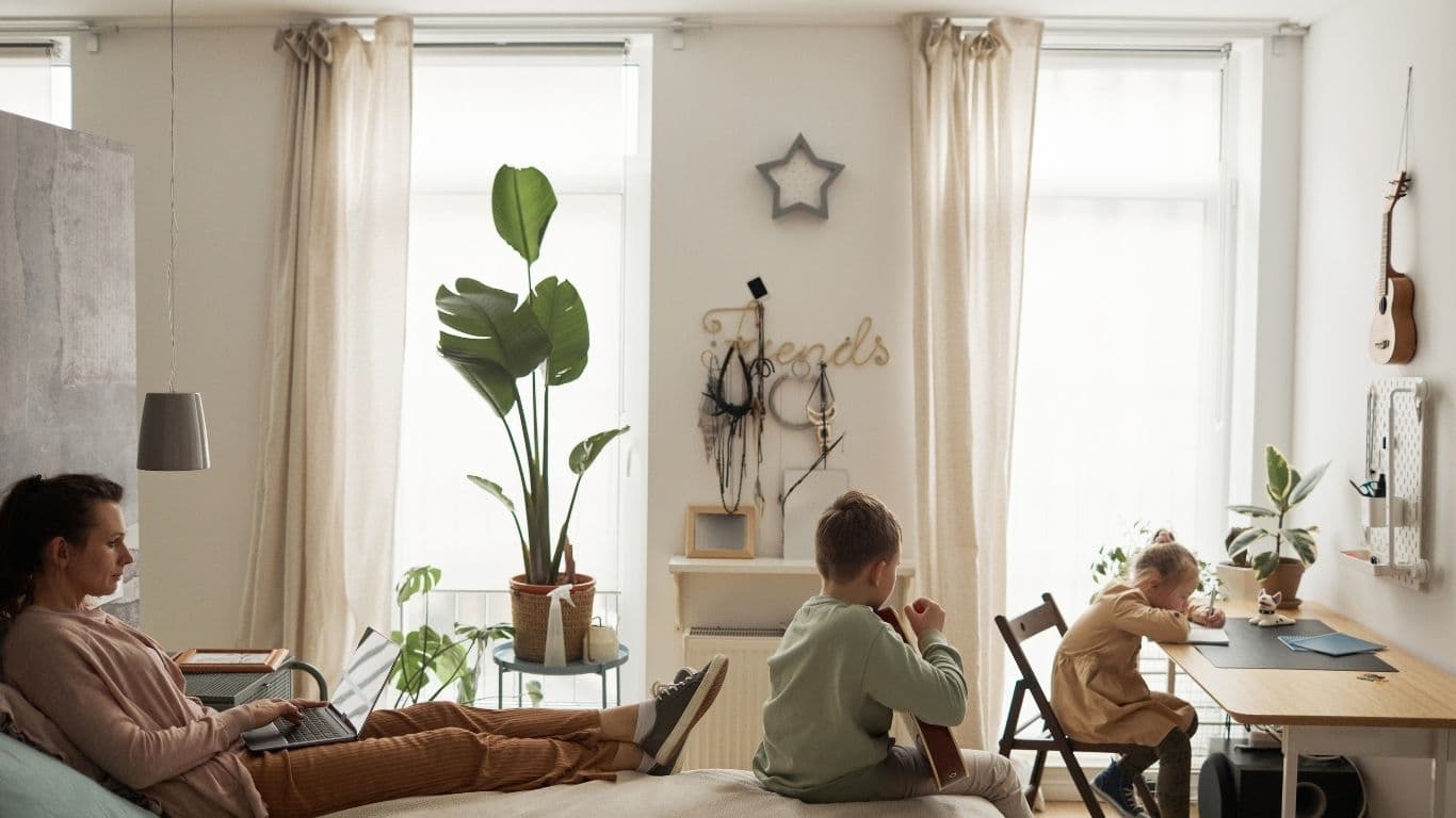 Erwachsene Person in einem Zimmer mit zwei Kindern.