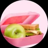 Icon einer pinken Brotdose mit grünem Apfel und Sandwich
